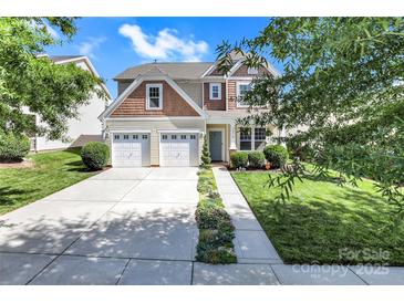 Charming two-story home featuring a two-car garage and inviting curb appeal with well-maintained landscaping at 2210 Winding River Dr, Charlotte, NC 28214