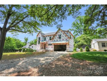 New construction home featuring a two-story design with an attached garage in a wooded location at 4918 Buckingham Dr, Charlotte, NC 28209