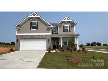 Charming two-story home featuring a brick and gray facade, well-manicured lawn, and a spacious two-car garage at 102 Cartington Way # Haf0042, Mooresville, NC 28115