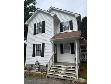 Charming two-story home with white siding, black shutters, and a welcoming front porch at 118 Fir St, Mcadenville, NC 28101