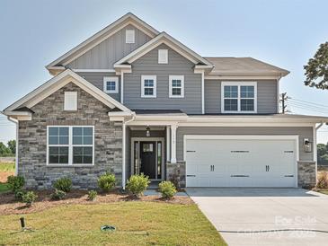 Beautiful two-story home with stone accents, gray siding, manicured lawn, and a two-car garage at 119 Tonbridge Way # Haf0033, Mooresville, NC 28115