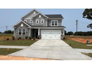 Two-story home featuring a gray color scheme, stone accents, a two-car garage, and a well-manicured front lawn at 119 Tonbridge Way # Haf0033, Mooresville, NC 28115