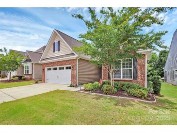 Charming home featuring brick and siding exterior, a two-car garage, and a well-maintained, landscaped front yard at 12014 Belmont Mansion Dr, Charlotte, NC 28273