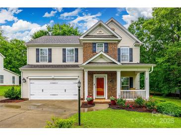 Charming two-story home featuring brick and siding exterior, a front porch, landscaped yard, and an attached two-car garage at 1206 Craig Ave, Lancaster, SC 29720