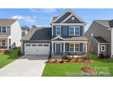 Charming two-story home with blue siding, stone accents, and a well-manicured lawn at 1216 Links Crossing Dr # 159, Monroe, NC 28112