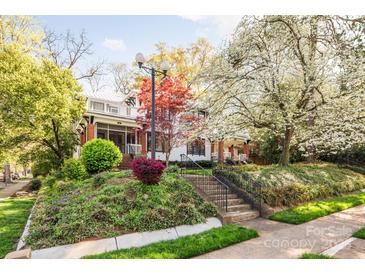 Charming two-story home with landscaped front yard and inviting front porch; perfect for relaxing in a peaceful setting at 1801 E 8Th St, Charlotte, NC 28204
