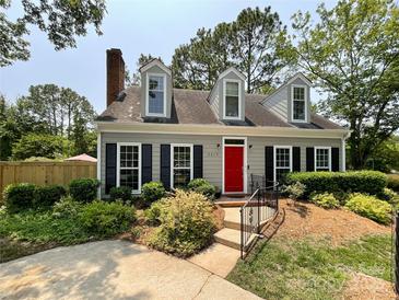 Charming home featuring a red door, black shutters, dormer windows, and beautifully landscaped front yard at 2619 Quailrush Rd, Charlotte, NC 28226