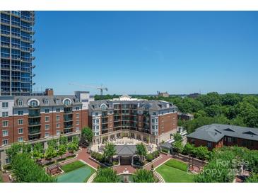 Expansive aerial view of a vibrant community featuring lush landscaping and elegant brick buildings with a city skyline backdrop at 300 W 5Th St # 812, Charlotte, NC 28202