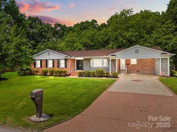 Charming brick home with manicured lawn, covered carport, and a classic American style at 303 Jean Ave, Kannapolis, NC 28083