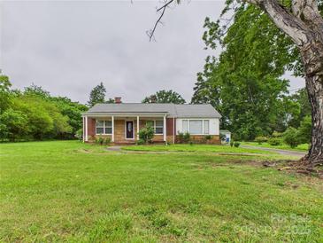 Charming brick and white home featuring a covered porch and expansive front yard at 3055 16Th Ne St, Hickory, NC 28601