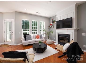 Bright living room featuring a fireplace, large windows, and modern furnishings at 3248 Margellina Dr, Charlotte, NC 28210