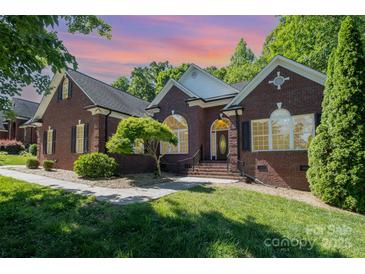 Charming brick home features a well-manicured lawn and a traditional design with black shutters at 3917 Erskine Woods Dr, Bessemer City, NC 28016