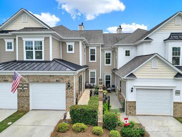 Charming townhome featuring a brick facade, attached garage, and manicured landscaping at 45008 Wigeon Ln # 202, Indian Land, SC 29707