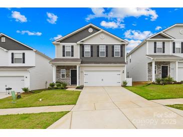 Charming two-story home features a two-car garage, stone accents, and manicured lawn at 5204 Belstone Ln, Charlotte, NC 28215