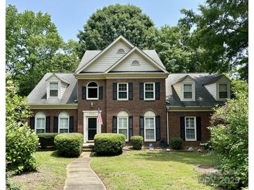 Traditional brick home with manicured lawn, black shutters, and well maintained landscaping at 9900 Colvard Cir, Charlotte, NC 28269