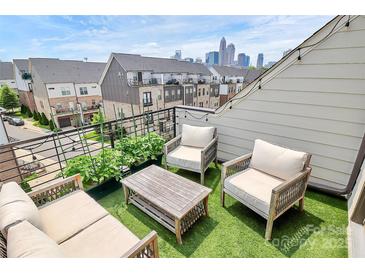 Inviting roof deck featuring comfortable seating, artificial turf, and a stunning view of the city skyline at 11043 Stetler St, Charlotte, NC 28204