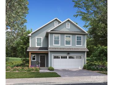 Charming two-story home featuring a light blue facade, white garage door, and a meticulously landscaped front yard at 1133 Thayer Glen Ct, Charlotte, NC 28213