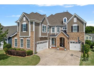 Beautiful two-story home featuring stone accents, neutral siding, a two-car garage, and a well-manicured lawn at 12214 Bonny Oaks Dr, Cornelius, NC 28031