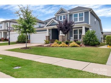 Charming two-story home with a manicured lawn, mature trees, and a welcoming front porch area at 1230 Therns Ferry Dr, Fort Mill, SC 29708