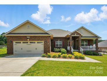 Charming brick home with a manicured lawn and inviting front porch, great curb appeal at 141 Tall Fern Loop, Mooresville, NC 28117