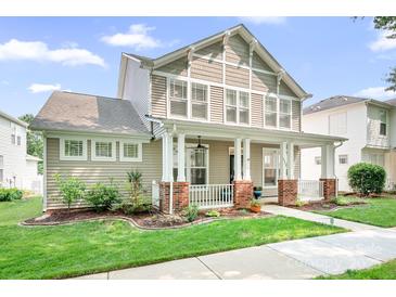 Charming two-story home featuring a welcoming front porch, lush landscaping, and classic architectural details at 14923 Almondell Dr, Huntersville, NC 28078
