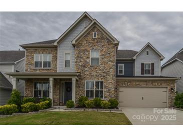 Beautiful two-story home featuring a stone facade, manicured lawn, and attached two-car garage at 15216 Shallow Ridge Rd, Charlotte, NC 28278