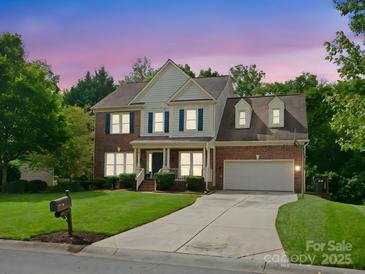 Charming two-story brick home featuring a manicured lawn and attached two-car garage at 2821 Providence Spring Ln, Charlotte, NC 28270