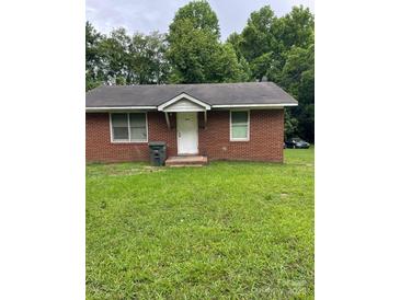 Charming single-story brick home featuring a well-maintained lawn and a classic white front door at 505 N Secrest Ave, Monroe, NC 28110