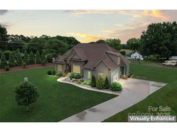 Beautiful exterior elevation of a two-story home showcasing stone accents, manicured lawn, and a paved driveway at 9125 Dylan Ridge Ct, Concord, NC 28027