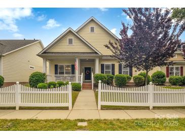 Charming home with a welcoming front porch and manicured landscaping with a picket fence at 1006 Phar Lap Dr, Indian Trail, NC 28079