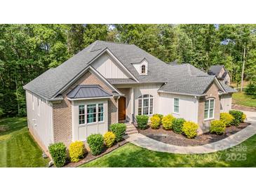 Inviting exterior showcasing a well-maintained lawn and charming curb appeal with stone and siding accents at 10874 Rise Ln, Fort Mill, SC 29707