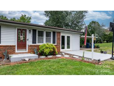 Charming home featuring brick accents, a well-manicured lawn, and a covered parking area at 1691 Hill River Rd, Hiddenite, NC 28636