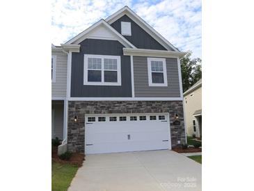 Two-story home featuring a two-car garage, stone accents, gray siding, and well-manicured lawn at 1922 Highland Park Dr, Charlotte, NC 28269