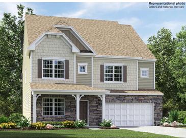 Charming two-story home featuring stone accents, a covered porch, attached garage, and lush landscaping at 4230 Skyboat Cir, Fort Mill, SC 29715