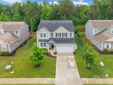 Aerial view of a two-story home with a well-manicured lawn and mature trees at 5130 Watersail Way, Clover, SC 29710