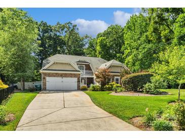 Charming home with a stone and siding exterior, attached garage, and well-manicured lawn at 1009 Jerry Ln, Matthews, NC 28105
