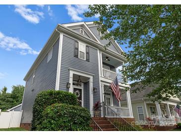 Charming two-story home with a welcoming porch and an American flag displayed at 14034 Holly Springs Dr, Huntersville, NC 28078