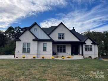 Charming, modern home with white brick, black trim, and lush green lawn at 1427 Kinks Ln # 47, Maiden, NC 28650