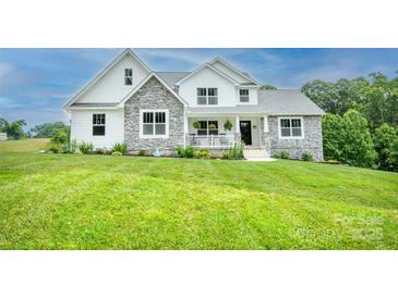 Charming two-story home with a stone and white exterior, lush green lawn, and inviting front porch at 164 Vance Farm Dr, Statesville, NC 28625