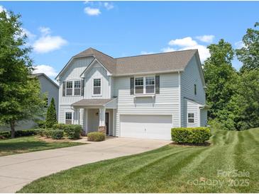 Well-manicured lawn and landscaping surround this light blue two-story home with a two-car garage at 4576 Fox Ridge Ln, Fort Mill, SC 29707