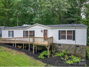 Charming home with a front porch, white siding, stone foundation, and surrounded by lush greenery at 6903 Knottywood Ln # 21, Vale, NC 28168
