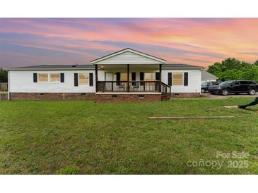 Charming ranch-style home with a welcoming front porch, lush lawn, and classic white siding at 7990 W Nc 152 Hwy, Mooresville, NC 28115