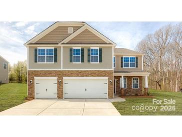 Charming two-story home with a stone facade and a spacious two-car garage at 8036 Kennesaw Dr, Gastonia, NC 28056
