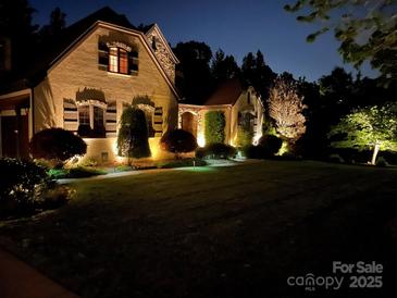 Charming home with lush lawn, mature trees, and tasteful landscape lighting at 1032 Seminole Dr, Waxhaw, NC 28173