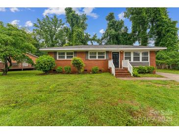 Charming single-story brick home with manicured lawn and inviting entrance, showcasing classic curb appeal at 1631 Vancouver Dr, Charlotte, NC 28213