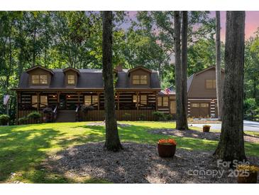 Charming log home with a covered porch, lush lawn, and mature trees at 2709 Blythe Rd, Waxhaw, NC 28173
