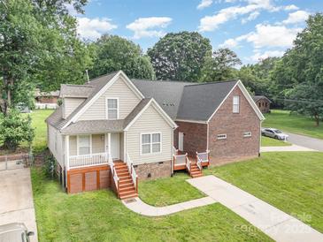 Inviting front view of a two-story home with wood deck, landscaped yard, and paved driveway on a sunny day at 5111 Clearwater Rd, Charlotte, NC 28217
