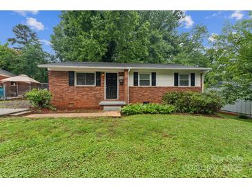 Charming single-story brick home featuring black shutters and a well-maintained front yard at 711 September Ln, Charlotte, NC 28208