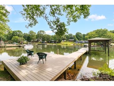 Inviting waterfront dock with seating, lush greenery, and picturesque lake views perfect for relaxation at 7232 Executive Cir, Denver, NC 28037