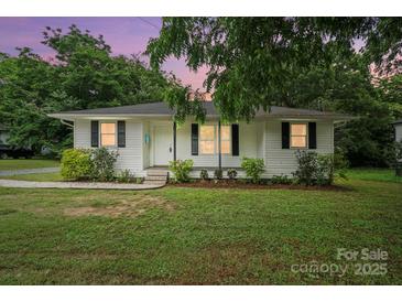 Charming single-story home featuring manicured landscaping and a classic white exterior at 107 S Branch St, Monroe, NC 28112